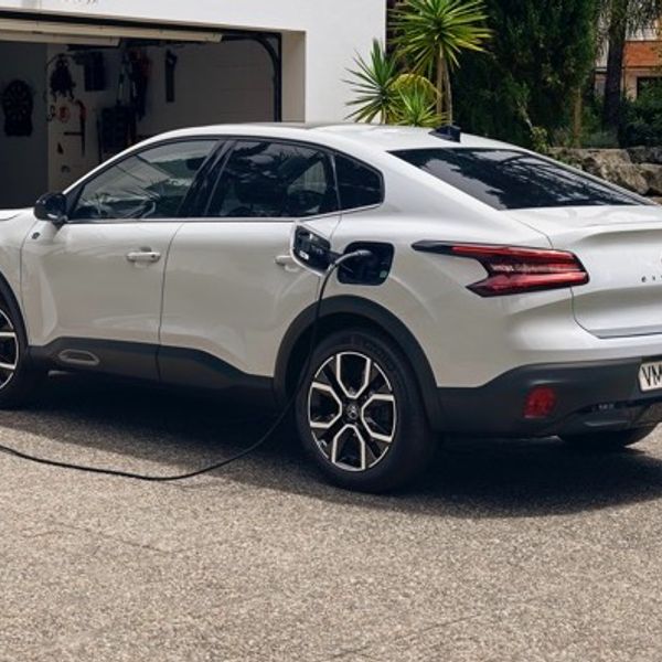 White Citroen e-C4X rear side profile view while charging